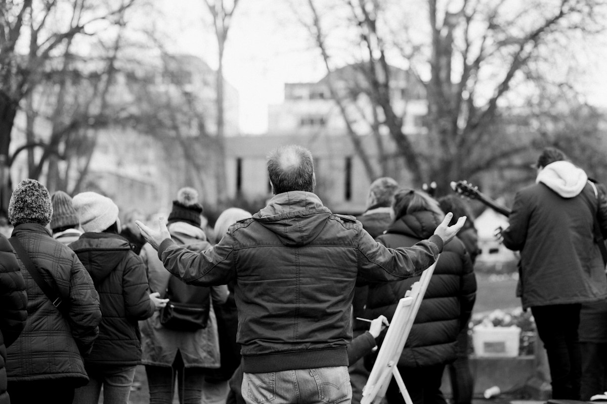 A group praying together outdoors on a city street during an outreach gathering